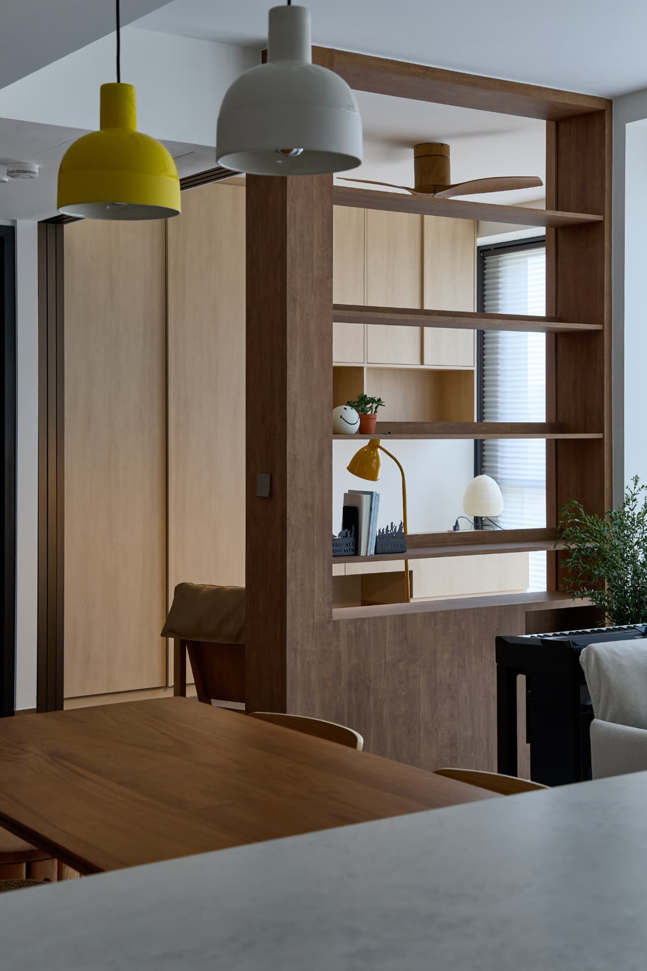 Timber room divider and shelving beside a dining space