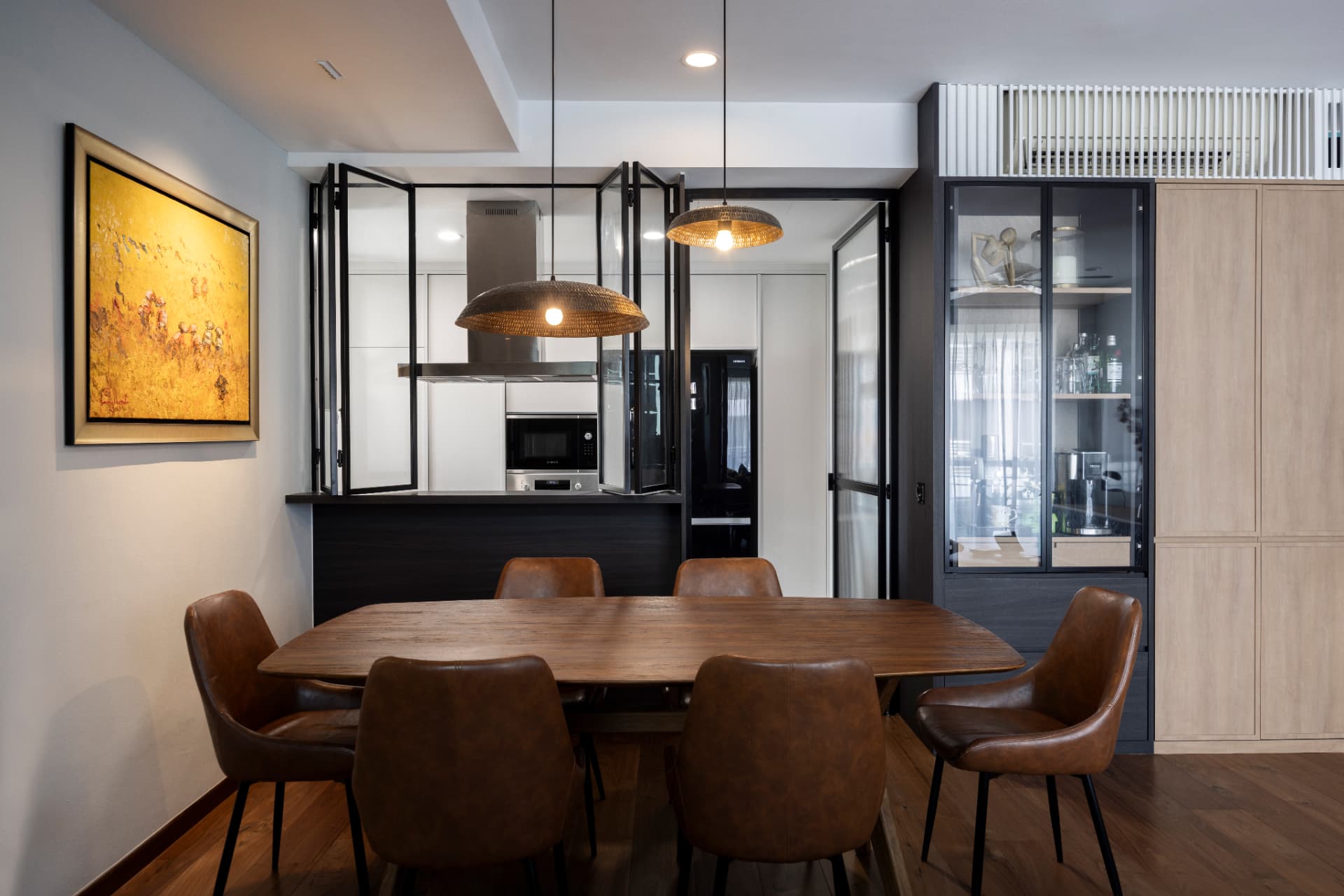Dining room with walnut table, pendant lamps and an enclosed kitchen