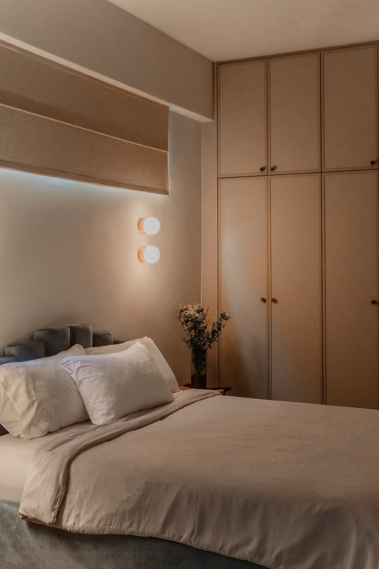 Calm bedroom with integrated cabinetry and warm wall lights